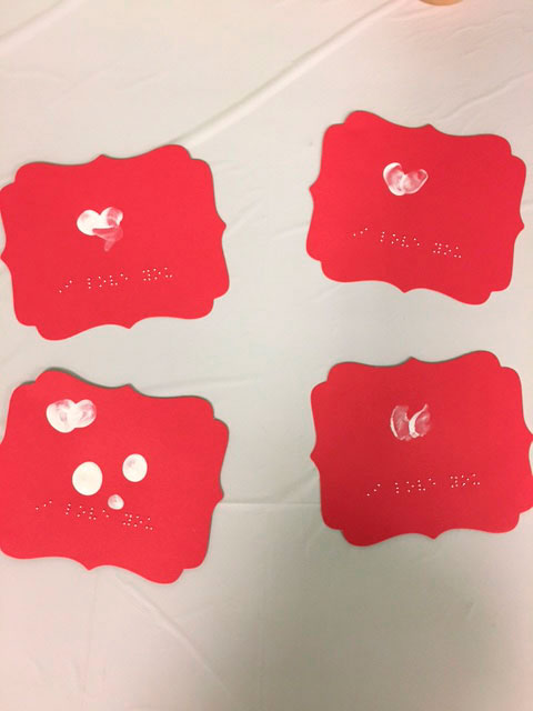 4 red valentine cards with white hearts and Braille that says -'I love you'.